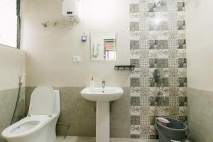 a bathroom with a white toilet and a sink at CueCasa in Guwahati +54 photos