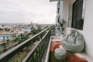 a balcony with a chair and a view of a city at CueCasa in Guwahati