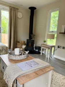 a living room with a table and a fireplace at The Willow Luxury Countryside Retreat in Stone