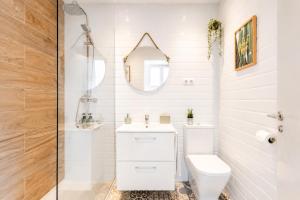 a white bathroom with a toilet and a mirror at New Central Studio Torremolinos in Torremolinos +70 photos