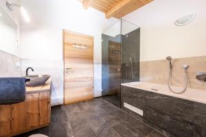 a bathroom with a tub and a sink and a shower at Kreuzplonhof Apt Karspitz in Luson +36 photos