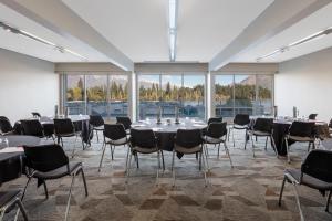 a conference room with tables and chairs and windows at Crowne Plaza Queenstown by IHG in Queenstown