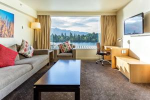 a living room with a couch and a large window at Crowne Plaza Queenstown by IHG in Queenstown