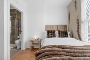 a bedroom with a large bed and a bathroom at Private Double Room in Spacious House with Garden in Blackrod