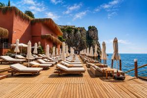 a row of lounge chairs and umbrellas on a pier at Massimo Hotel - Adults Only 'Ex La Boutique Hotels' in Antalya