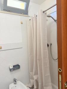 a bathroom with a white shower curtain and a toilet at Casina Toscana in Certaldo +6 photos