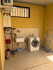 a bathroom with a washing machine and a sink at Casina Toscana in Certaldo