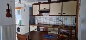 a kitchen with a table and a white refrigerator at Villa Michalis in Theológos +16 photos