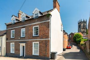 a brick building with a clock tower in the background at St James House Timeless Comfort Central Congleton in Congleton