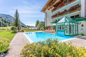 a swimming pool in front of a building at Berghof-Chalet in Erpfendorf