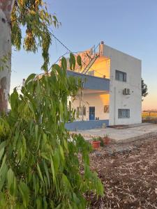 a building with a crane on top of it at Beit Philodemus 2 - IRIS in Um Qeis