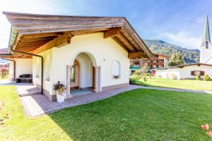 a small white church with a grass yard at Berghof-Chalet in Erpfendorf