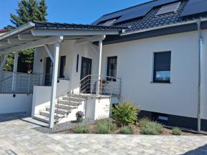 a white house with a porch and stairs at Auszeit in Storkow