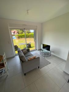 a living room with a couch and a tv at La grange du clos in Angiens