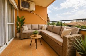 a patio with a couch and a table on a balcony at BlueSabinillas in San Luis de Sabinillas