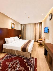 a hotel room with a large bed and a desk at فندق الأرضُ المتميزه - Land Prime -1 in Mecca +18 photos