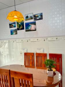 a dining room table with chairs and a potted plant at Cát Home in Phú Hiệp