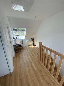 a room with a staircase and a desk and a window at La grange du clos in Angiens