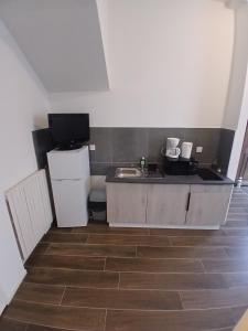 a small kitchen with a sink and a refrigerator at Joli t1 bis Drôme des collines in Saint-Vallier