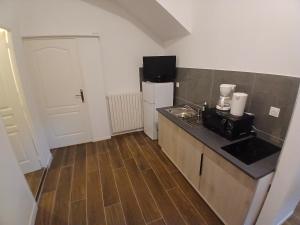 a small kitchen with a sink and a refrigerator at Joli t1 bis Drôme des collines in Saint-Vallier