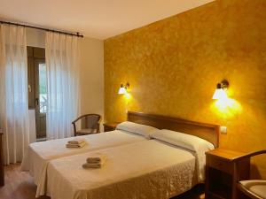a bedroom with a bed with two towels on it at Hotel Covadonga in Cangas de Onís
