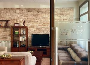 a living room with a couch and a television at Hotel Covadonga in Cangas de Onís