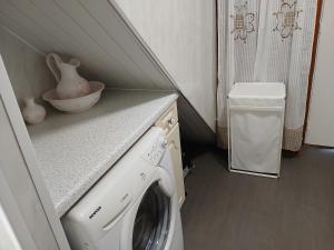a washing machine in a laundry room with a counter at Les 4 Portes in Le Mesnillard