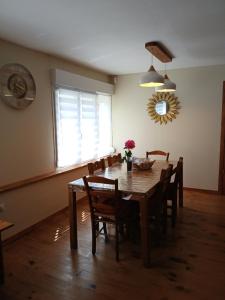 a dining room table with chairs and a window at Les 4 Portes in Le Mesnillard