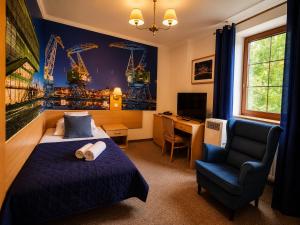 ein Schlafzimmer mit Bett, Stuhl und Schreibtisch in der Unterkunft Hotel Bończa in Stettin