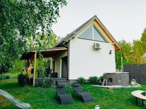 a group of chairs sitting in a yard next to a house at Świtówka - Domek z balią ogrodową in Żnin