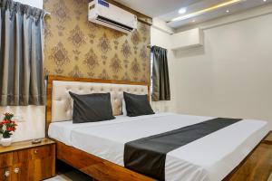 a bedroom with a large bed with white sheets at Collection O Dehu Alandi Road Formerly KP Pride in Dehu