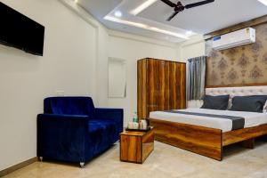 a bedroom with a bed and a blue chair at Collection O Dehu Alandi Road Formerly KP Pride in Dehu +20 photos
