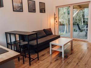 a living room with a couch and a table at Świtówka - Domek z balią ogrodową in Żnin
