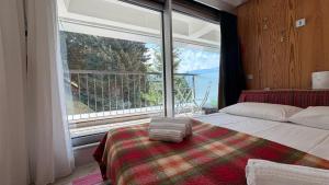 a bedroom with a bed and a large window at Appartamento Cinzia Residence Solaria Marilleva 1400 in Marilleva +77 photos