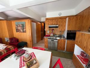 a kitchen and living room with wooden cabinets at Appartamento Cinzia Residence Solaria Marilleva 1400 in Marilleva