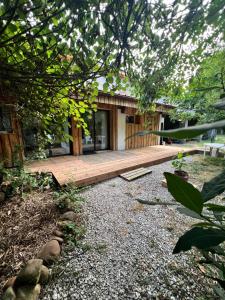 a house with a wooden deck in front of it at Studio famille, lit aventurier in Saint-Laurent-de-Neste