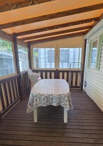 a covered porch with a table and a chair at Camping les sables in Aytré +3 photos