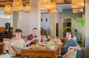 a group of people sitting around a table eating food at Crystal springs mount face Hotel in Ella +30 photos
