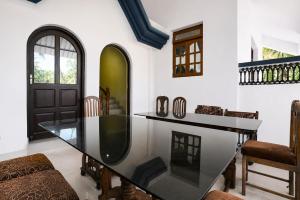 a dining room with a glass table and chairs at Triple Beach Guest House in Benaulim +27 photos