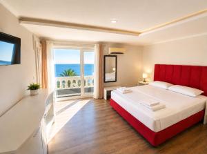 a bedroom with a red bed and a large window at Shala Resort & SPA in Durrës +18 photos