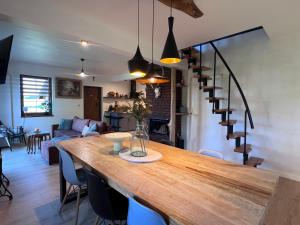 a kitchen and living room with a large wooden table at Dom Na Wsi z Balią Ogrodową-Jacuzzi in Mierzwin Duży