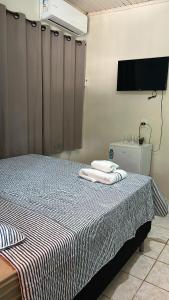 a bedroom with a bed with two towels on it at Bela Vista Pousada Alter in Alter do Chao