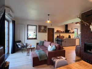 a living room with a couch and a kitchen at Dom Na Wsi z Balią Ogrodową-Jacuzzi in Mierzwin Duży +36 photos