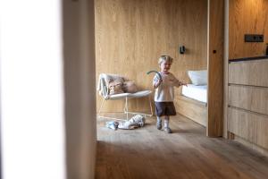 a little boy standing in a bedroom with a toothbrush at Eco by Nature - De Stilte - in Heythuysen
