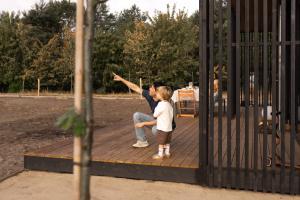 a man and a child standing on a wooden deck at Eco by Nature - De Stilte - in Heythuysen +29 photos
