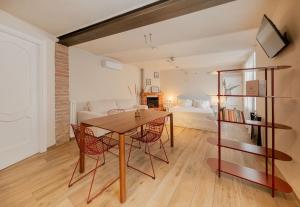 a dining room with a table and chairs and a living room at Villa Curte Nicia in Nizza Monferrato