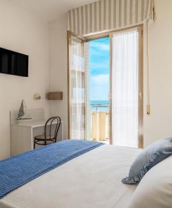 a bedroom with a bed with a view of the ocean at Hotel Leonardo da Vinci in Pesaro