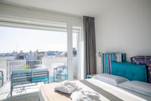 a bedroom with a bed and a balcony with a view at Hotel Cicò in Torre Santa Sabina
