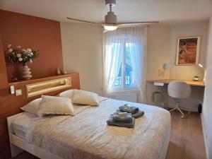 a bedroom with a bed with towels on it at L'Appart Millésime - Escapade champenoise Épernay in Magenta +12 photos