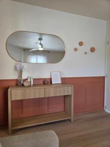 a living room with a mirror and a wooden table at L'Appart Millésime - Escapade champenoise Épernay in Magenta
